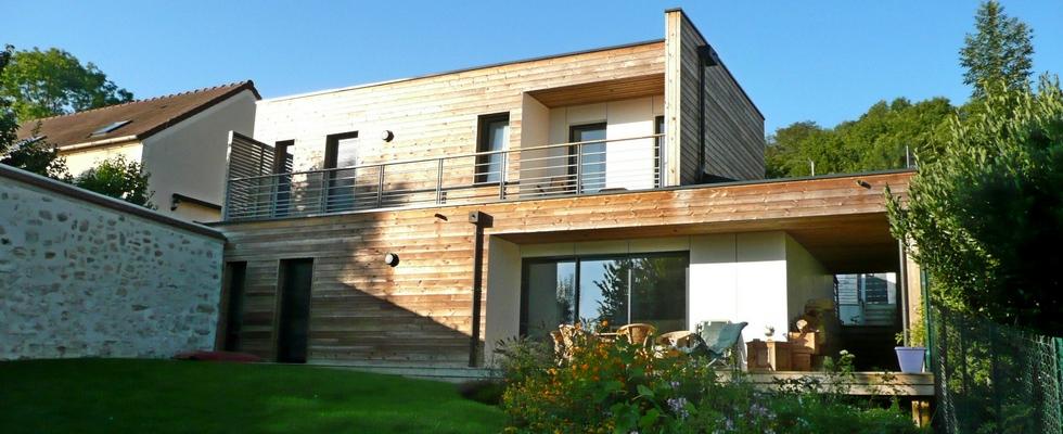 Maison en ossature bois et bardage en bois naturel, toit plat, garage, plusieurs niveaux en décalé.